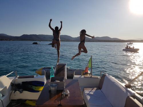 Boys jump off the boat at sunset