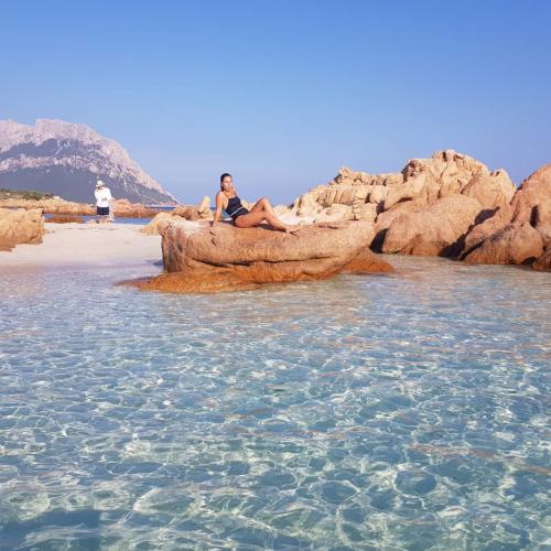 Girl relaxes on a beach in front of Tavolara