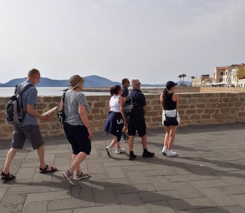 <p>Randonneurs pendant la visite guidée de la ville à Alghero avec vue sur la mer</p>