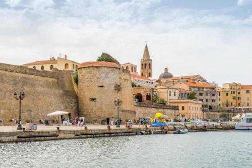 <p>Rue caractéristique d’Alghero avec vue sur la mer</p>