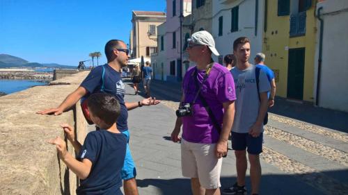 <p>Wanderer bei geführter Stadtrundfahrt in Alghero mit Meerblick</p>