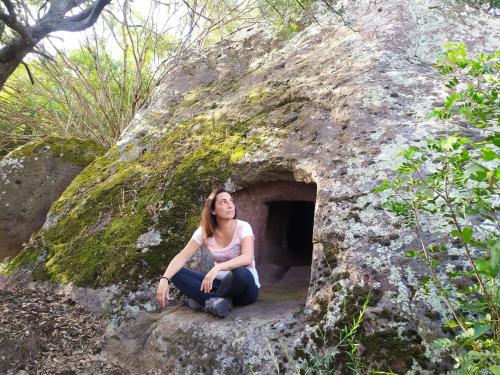 <p>Entrée de la Domus de janas Marajana à Allai avec randonneur</p><p><br></p>