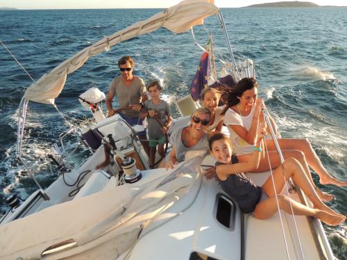 Famiglia con bambini si diverte a bordo di una barca a vela