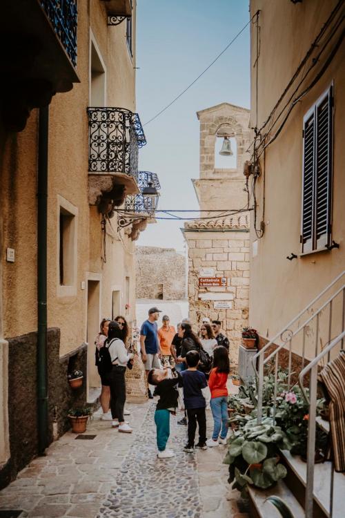 Menschen schlendern durch die Straßen von Castelsardo