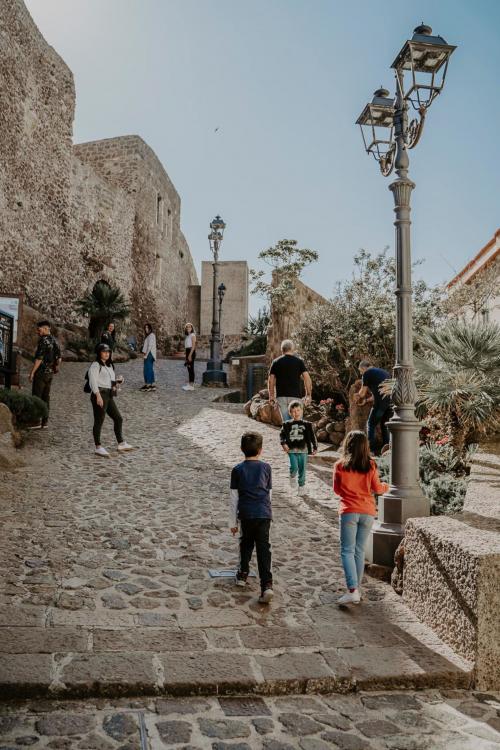 Menschen schlendern durch die Straßen von Castelsardo