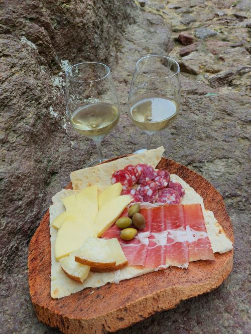 Gläser Weißwein mit Platte mit typisch sardischen Produkten in Castelsardo