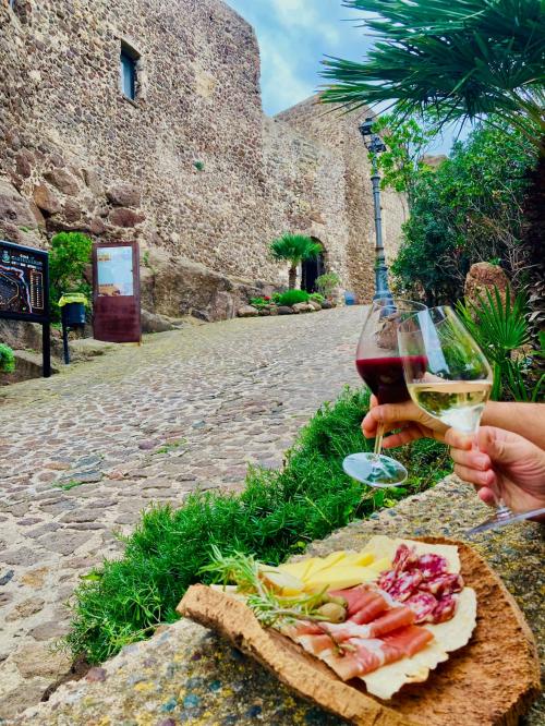 Brindisi calice di vino rosso e bianco nelle vie di Castelsardo