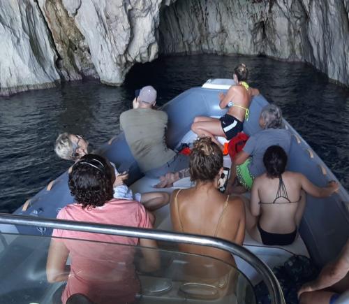 Group of hikers aboard a rubber dinghy in Masua