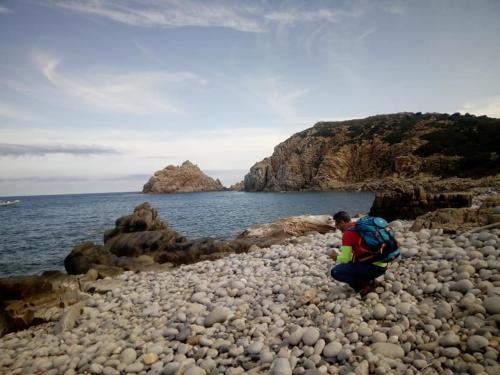 Escursionista e spiaggia con ciottoli