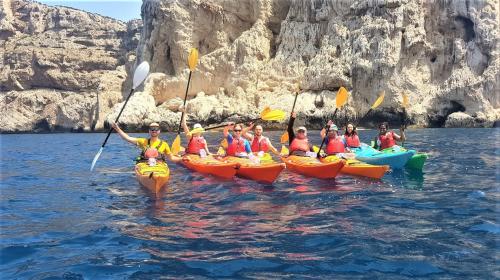 Gruppi di persone in kayak durante tour guidato nel mare di Alghero
