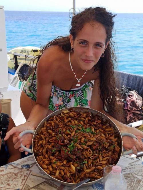 Ragazza con pasta cucinata a bordo