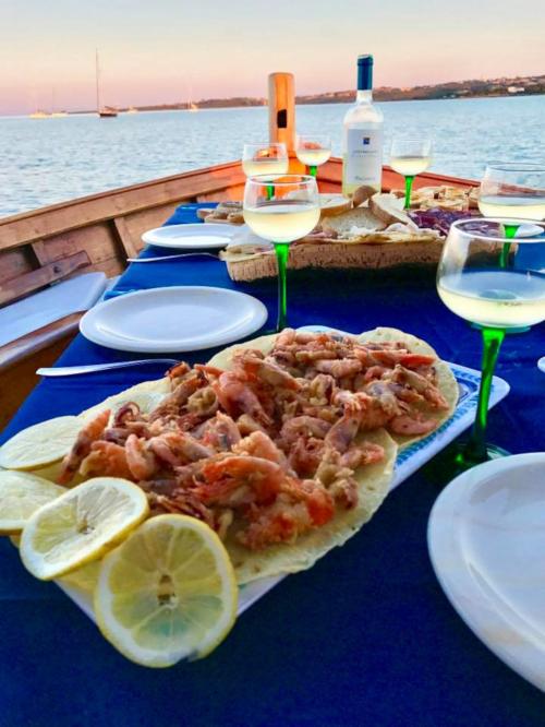 Fish and white wine served aboard the gozzo in Asinara
