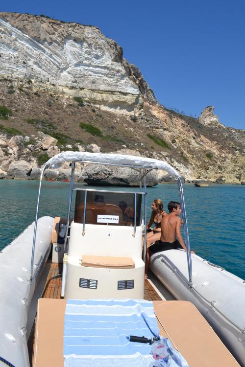 Schlauchboot mit Jungen in der Nähe des Riffs im Golf von Cagliari