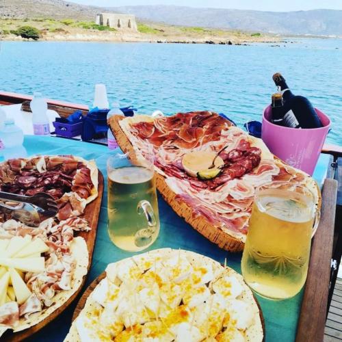 Abbondante aperitivo di prodotti tipici sardi e vino a bianco a bordo di un veliero all'Asinara