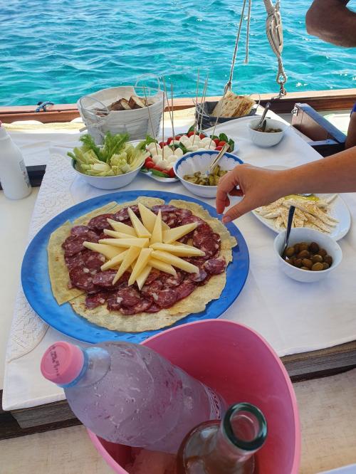 Aperitivo di salumi e formaggi e altri prodotti tipici sardi a bordo di un veliero all'Asinara