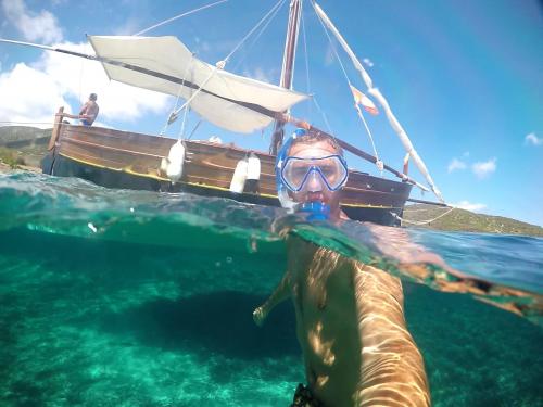 Boy snorkeling during a day trip in a vintage sailing ship