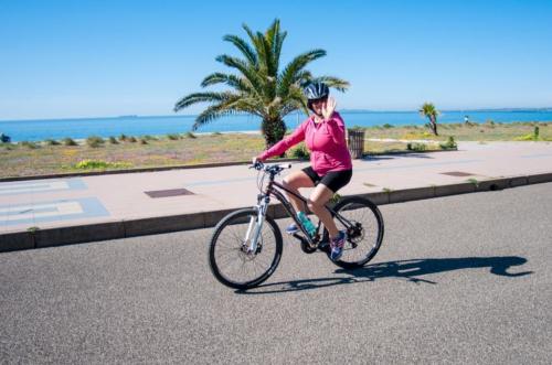 Dame auf dem Fahrrad in der Uferpromenade