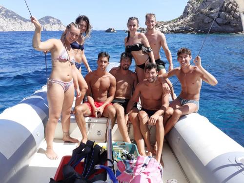 Group of friends on board an inflatable boat with skipper in Tavolara