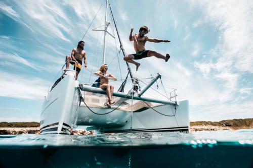 Des garçons sautent du catamaran lors d'une excursion dans l'archipel de La Maddalena