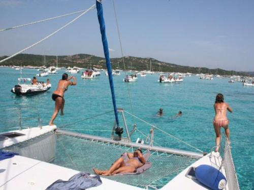 People dive off the catamaran among the Islets of the La Maddalena Archipelago from the catamaran