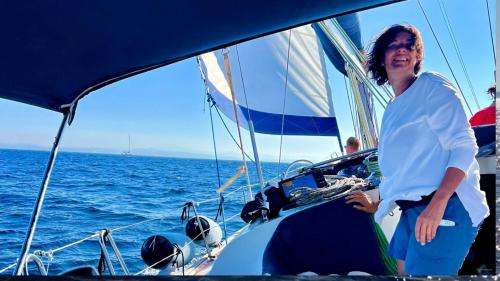 Ragazza a bordo della barca a vela mentre naviga nelle acque dell'arcipelago di La Maddalena