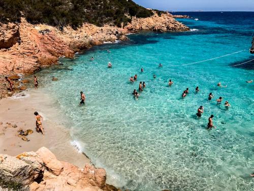 Hikers swim in Spargi during a boat tour