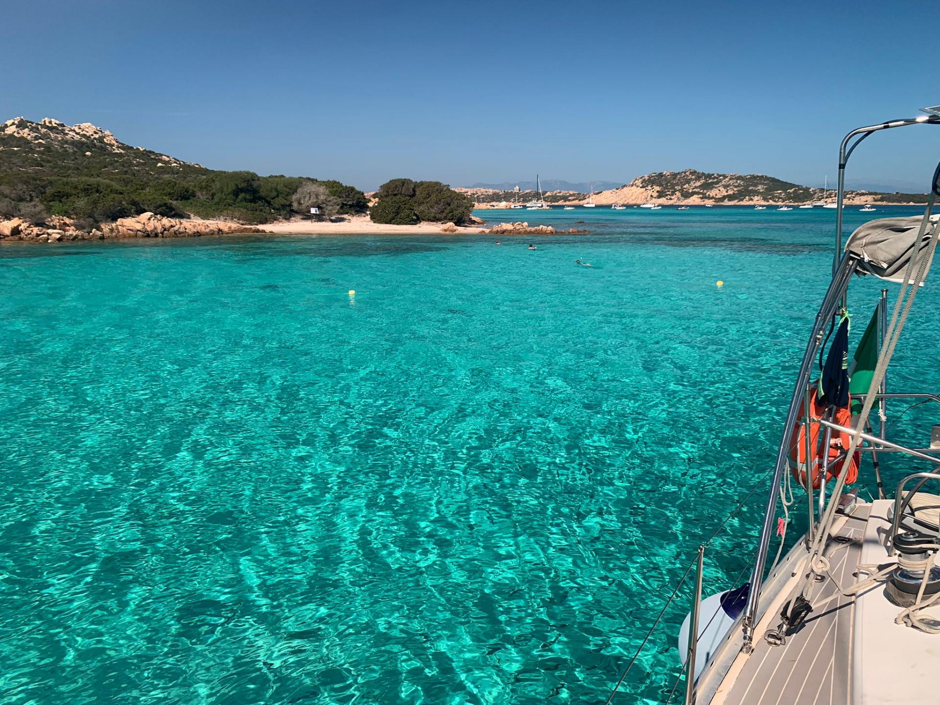 Sailing boat in the crystal clear sea in the Corsica Archipelago between Lavezzi and Piana Island