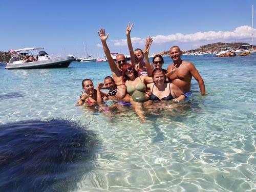 Crystal clear sea and group of hikers during a day tour in Corsica