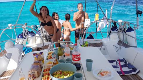 Hikers during lunch on a sailing boat in the north of Sardinia