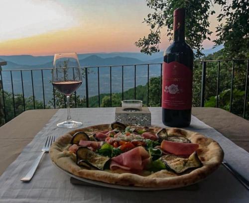 Pizza mit lokalem Rotwein mit Panoramablick auf die Berge