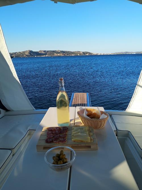 Aperitivo con bottiglia di vino bianco a bordo di una barca nell'Arcipelago di La Maddalena