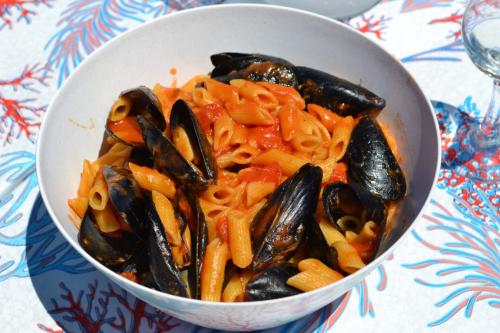Pasta with mussels on board a wooden gozzo in Asinara